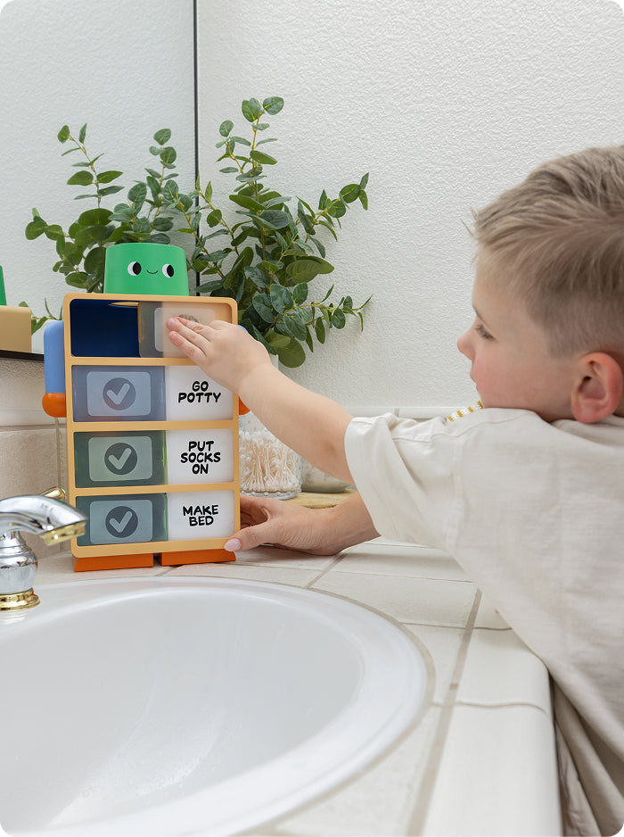 Child using the Routine Robot to follow a bathroom routine