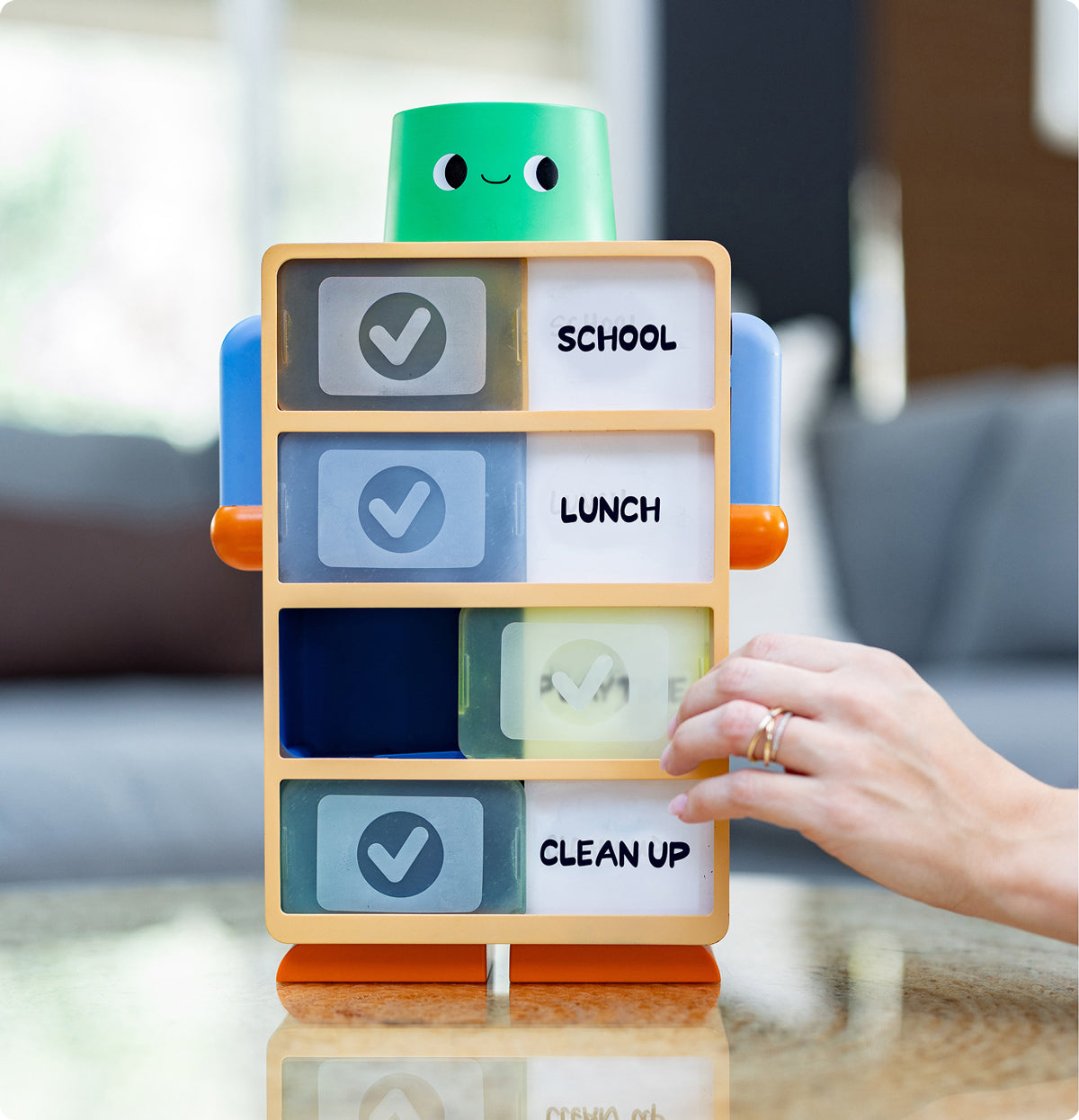 Mother checking off routine with the Routine Robot on the floor